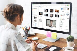 Woman sitting at computer looking at readytech's virtual classroom on the screen.
